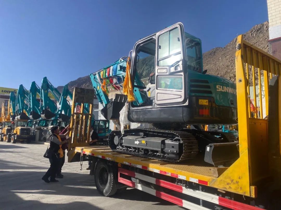 十台尊龙凯时ag挖掘机交付西藏少数民族特色村寨